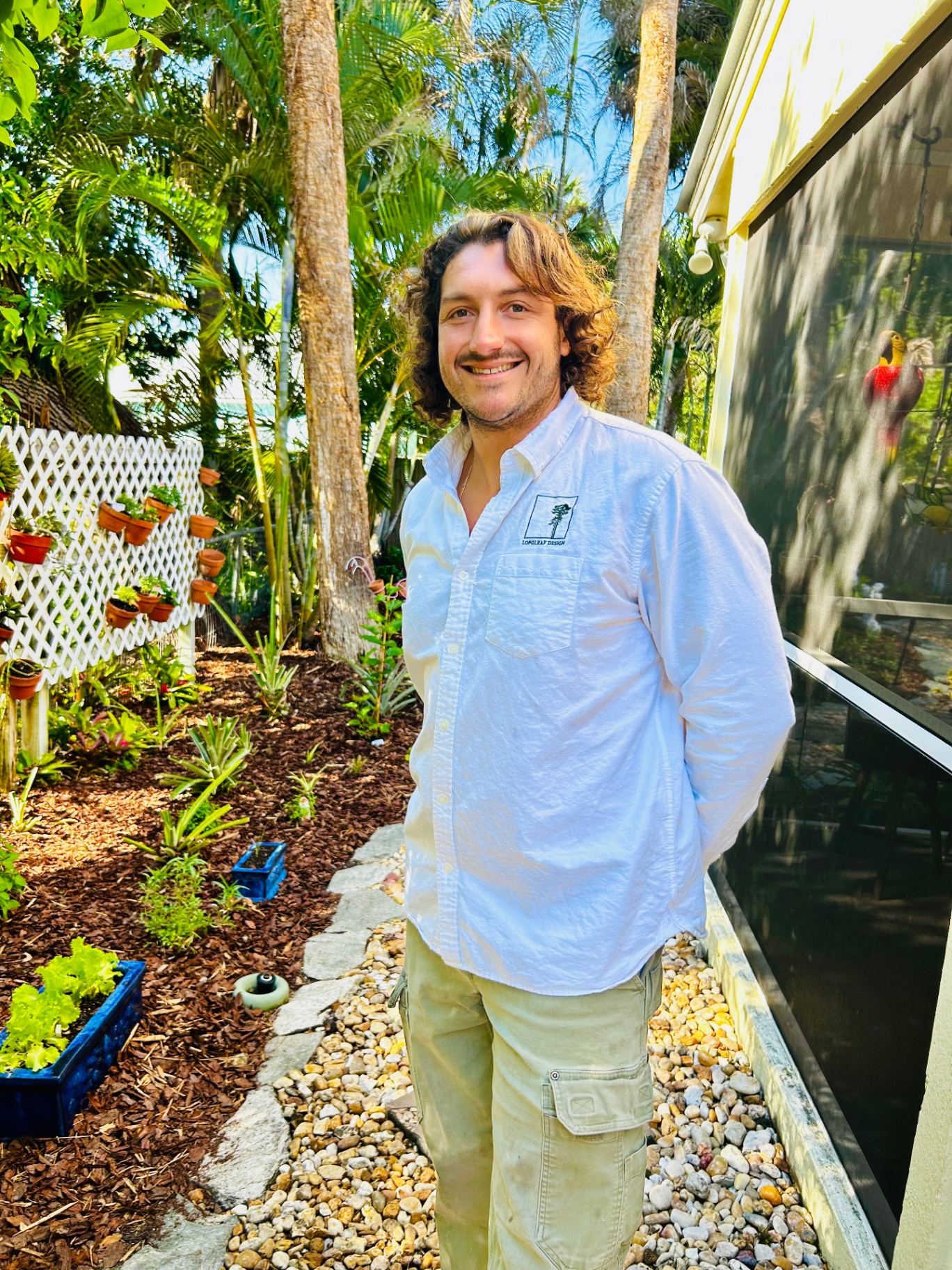 Cam Maletto, landscape designer at Longleaf Design, standing in a Florida garden.